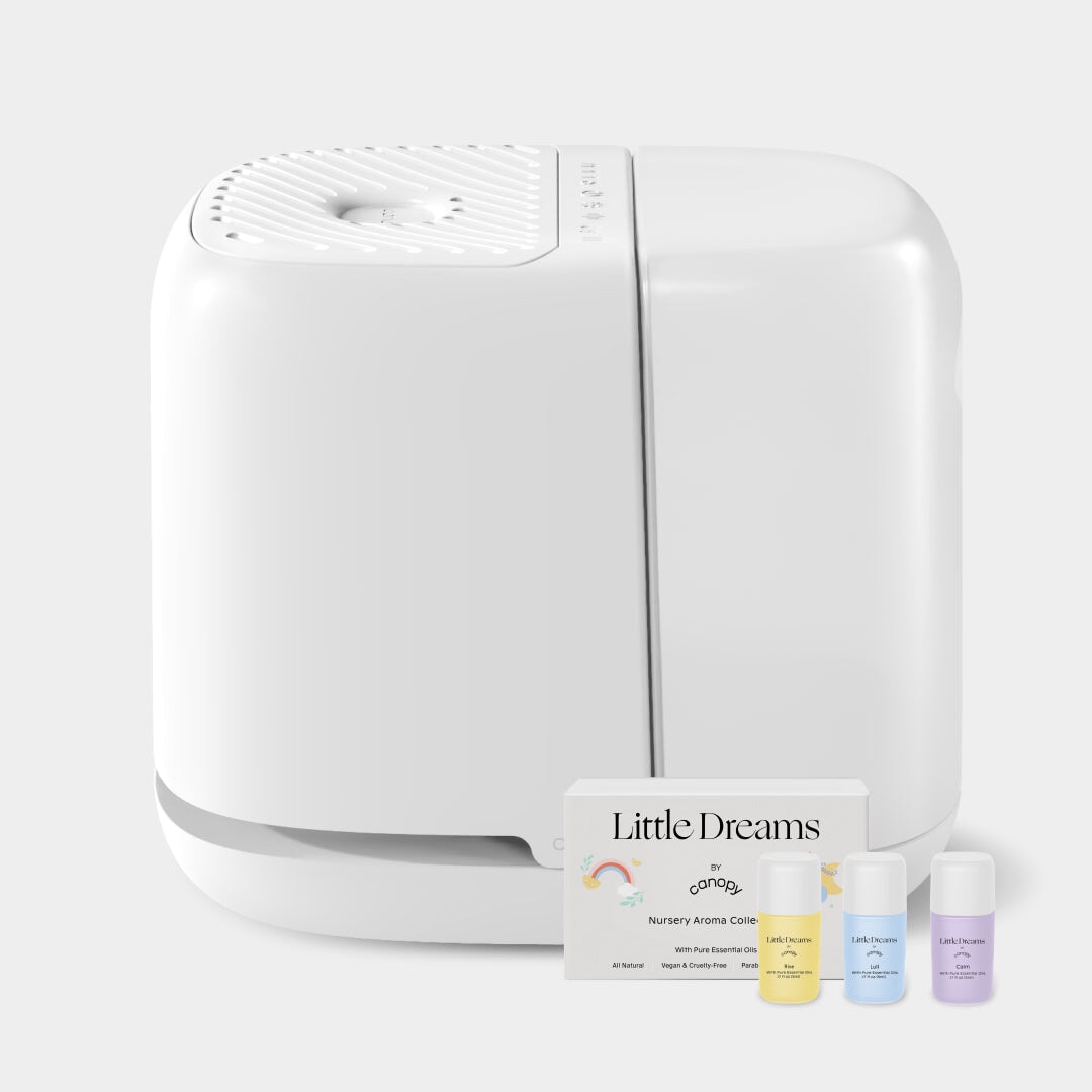White Canopy Nursery Humidifier 2.0 with the Little Dreams aroma collection shown beside the machine; official product-page image, package presentation.