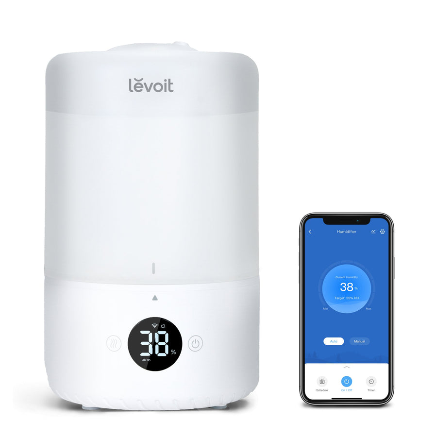 White Levoit Dual 200S with a humidity percentage display and a phone showing app controls.
