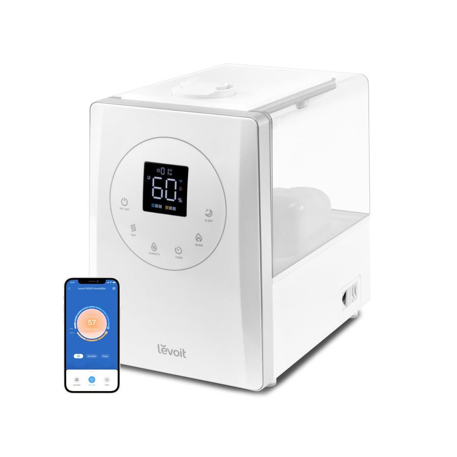 White Levoit LV600S smart hybrid humidifier with display and a phone showing humidity settings